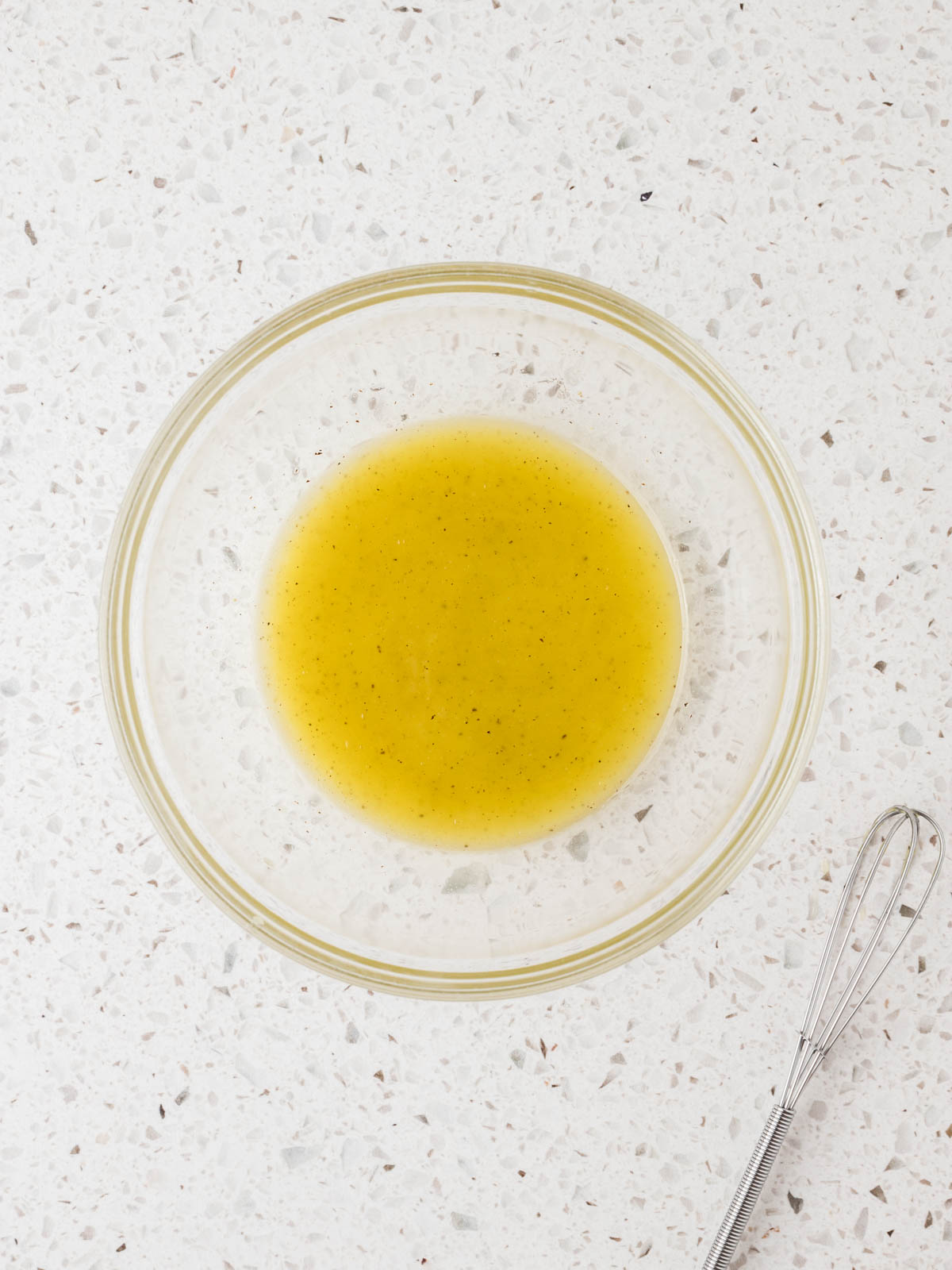 Lemon juice, olive oil, kosher salt, and pepper in a small mixing bowl whisked together. 