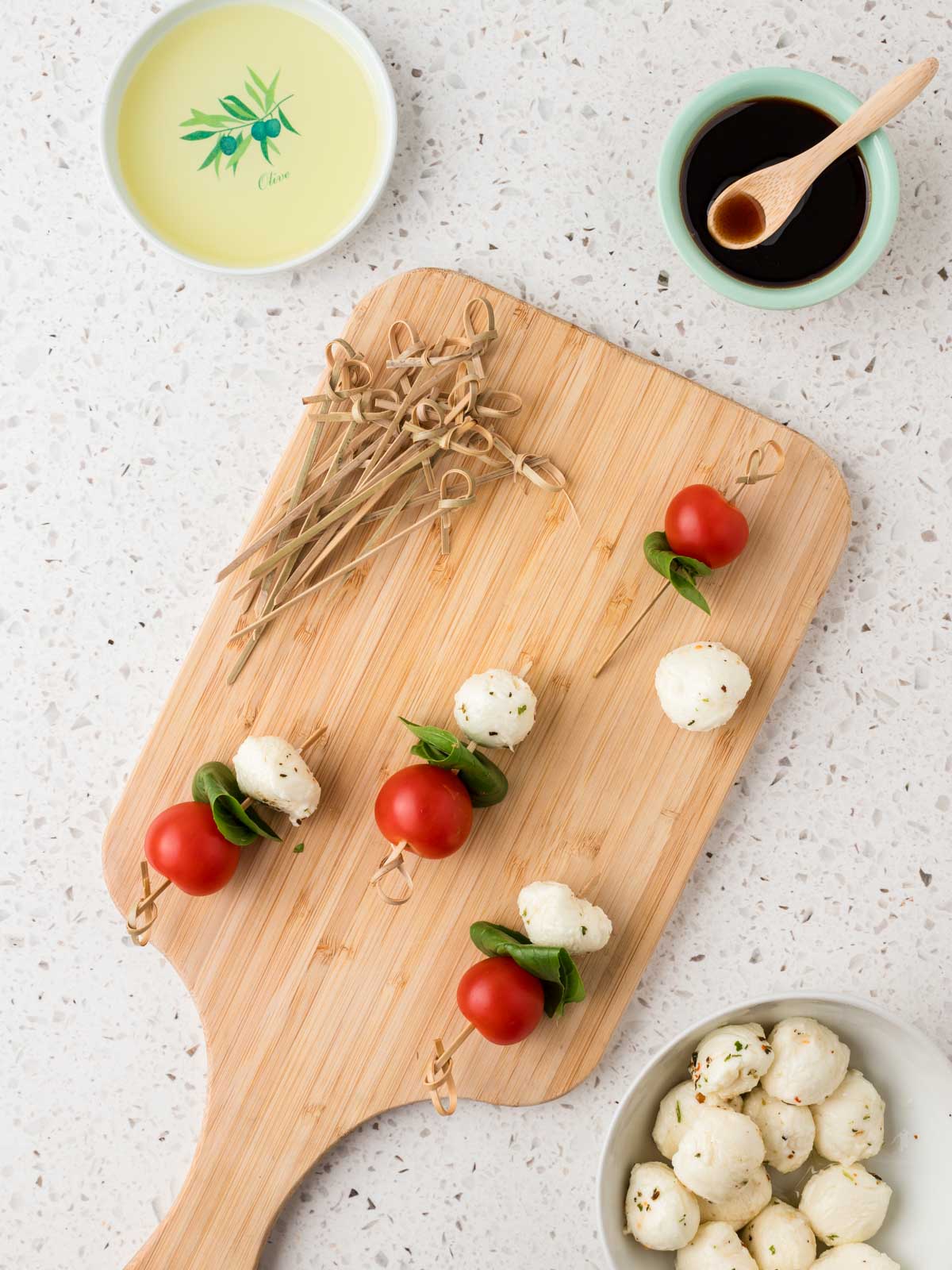 Cherry tomato, basil leave and mozzarella ball threaded onto skewer. 