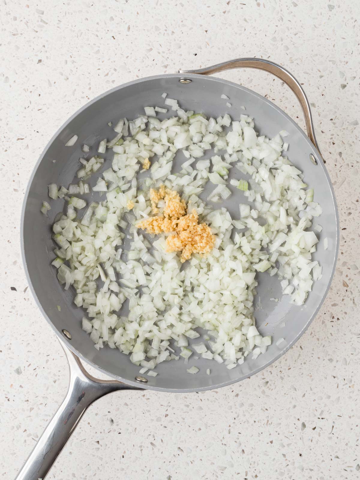 Sauteed onions in a pan with minced garlic.