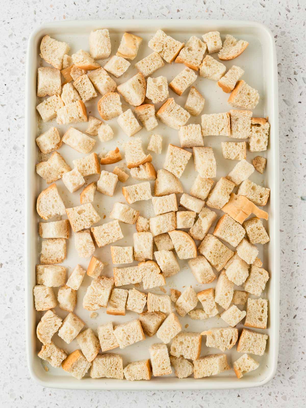 Cubed stale bread on a sheet pan. 