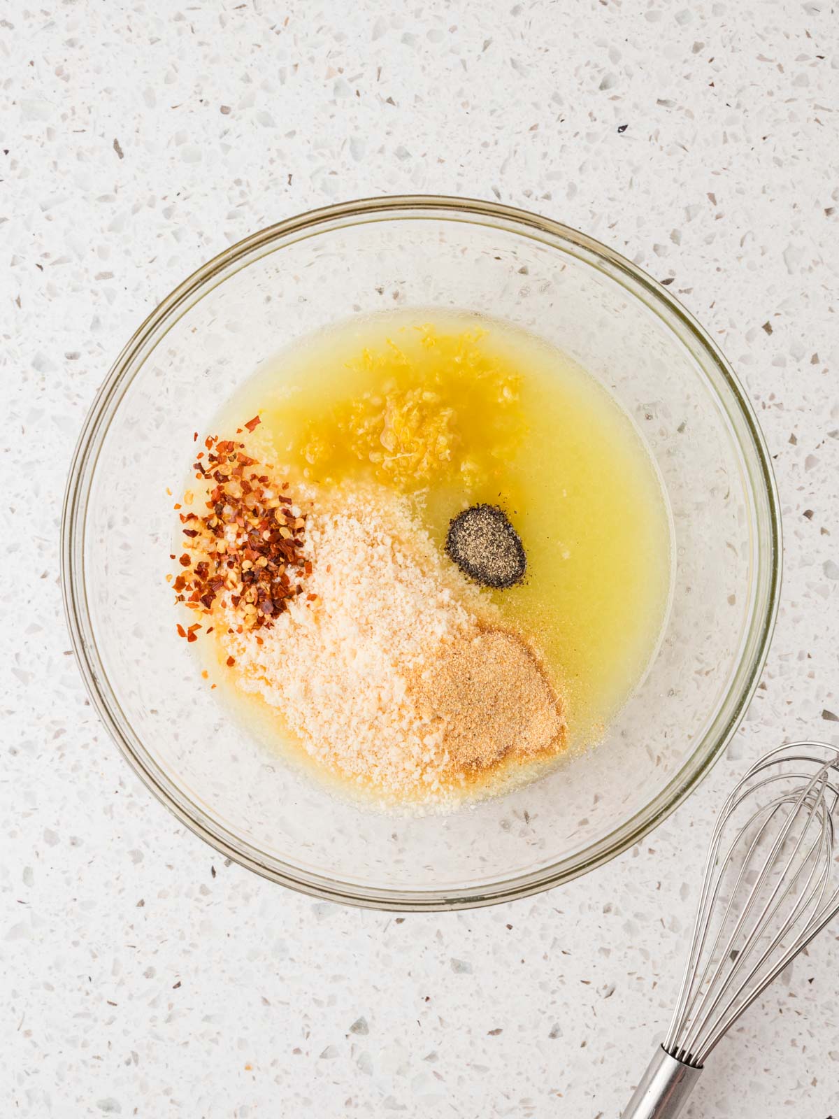 Lemon juice, olive oil, and seasonings in a small bowl with a whisk.