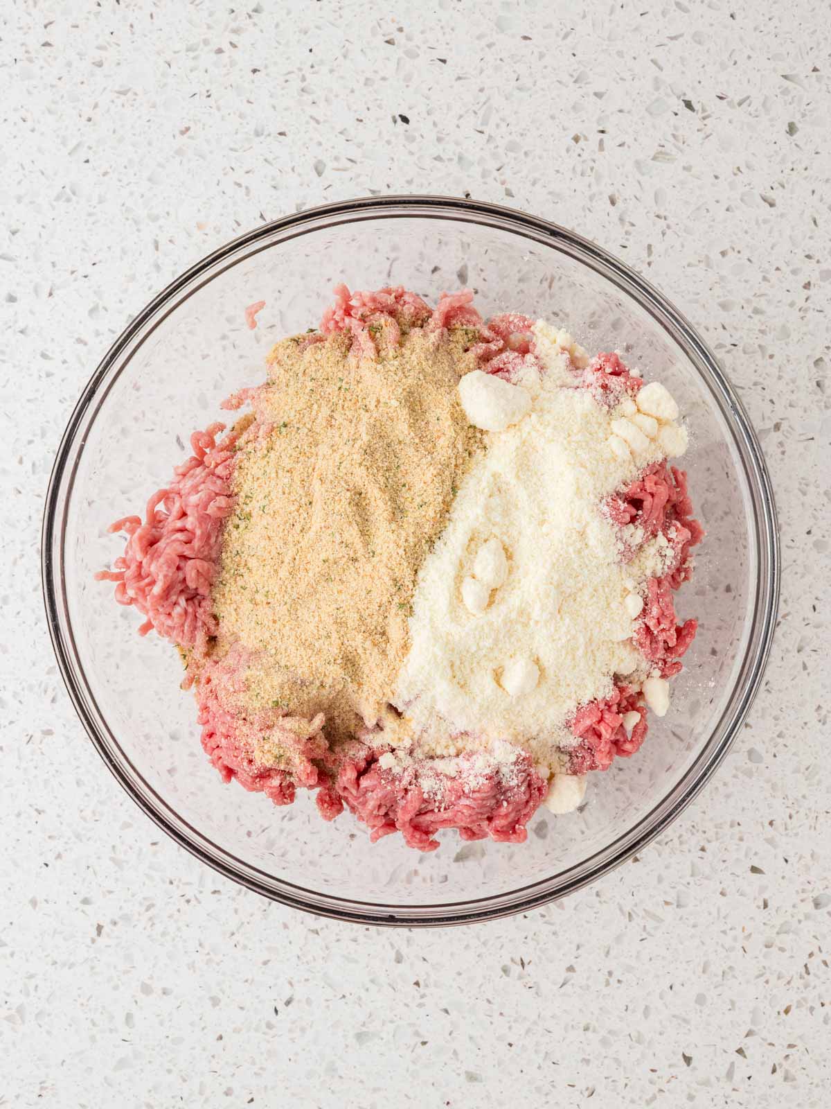 Ground beef, ground pork, parmesan cheese and bread crumbs in a large mixing bowl.