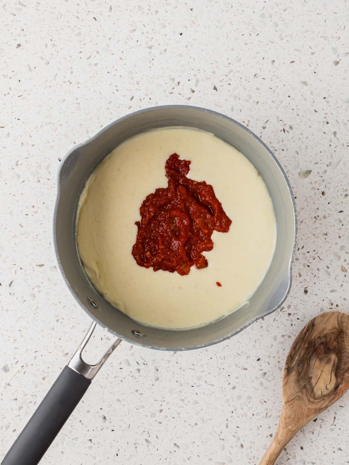 Alfredo sauce with marinara sauce in a sauce pan.