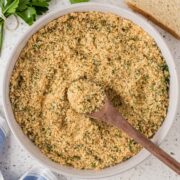 Homemade Italian breadcrumbs in a serving bowl with a wooden spoon.