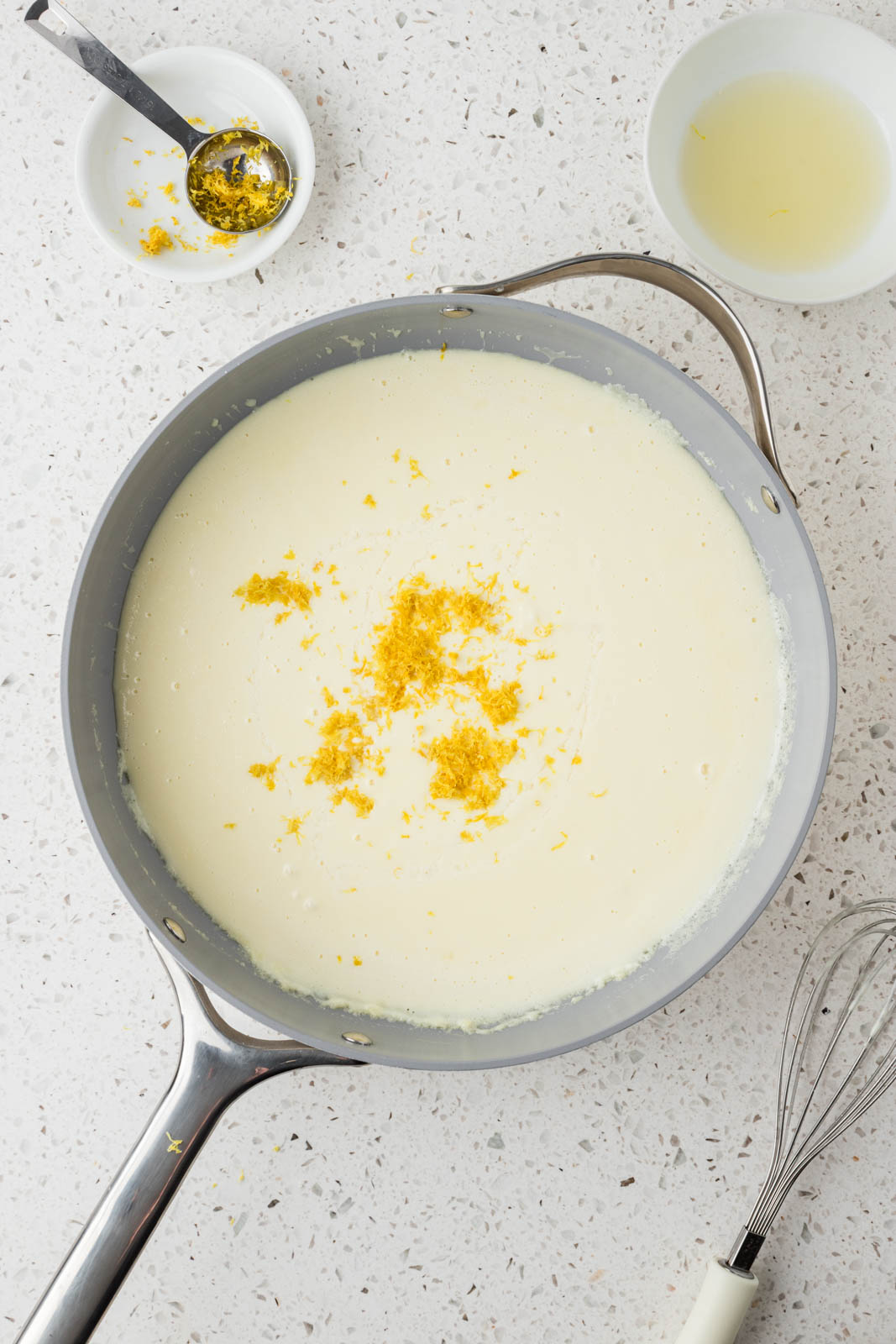 Alfredo sauce plus lemon zest in a pan.