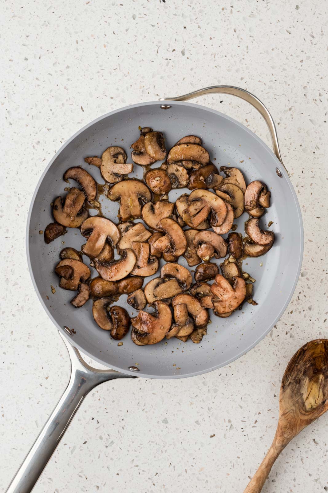 Sauteed baby bella mushrooms in a pan.
