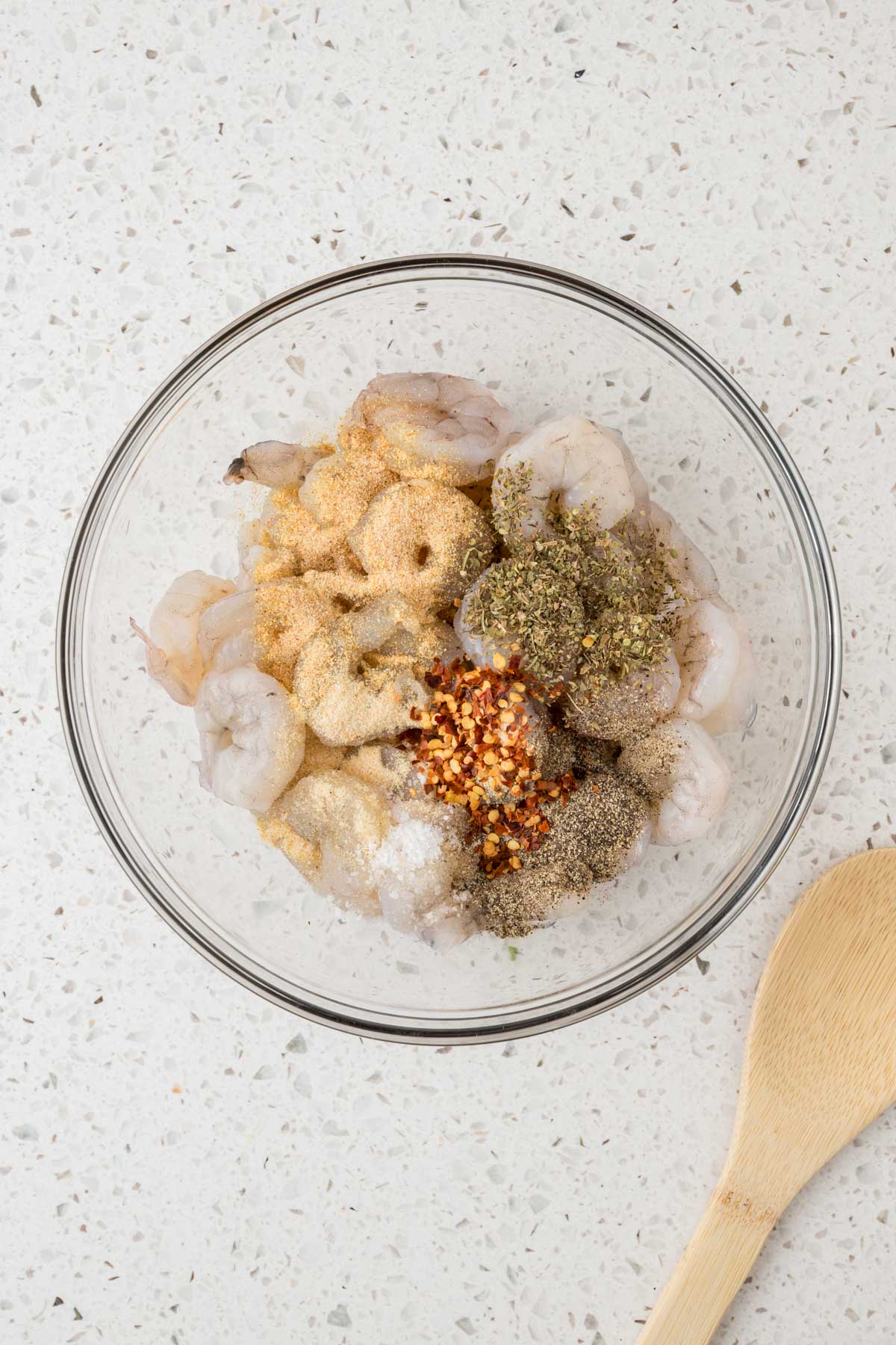 Raw shrimp in a bowl with all the seasonings.