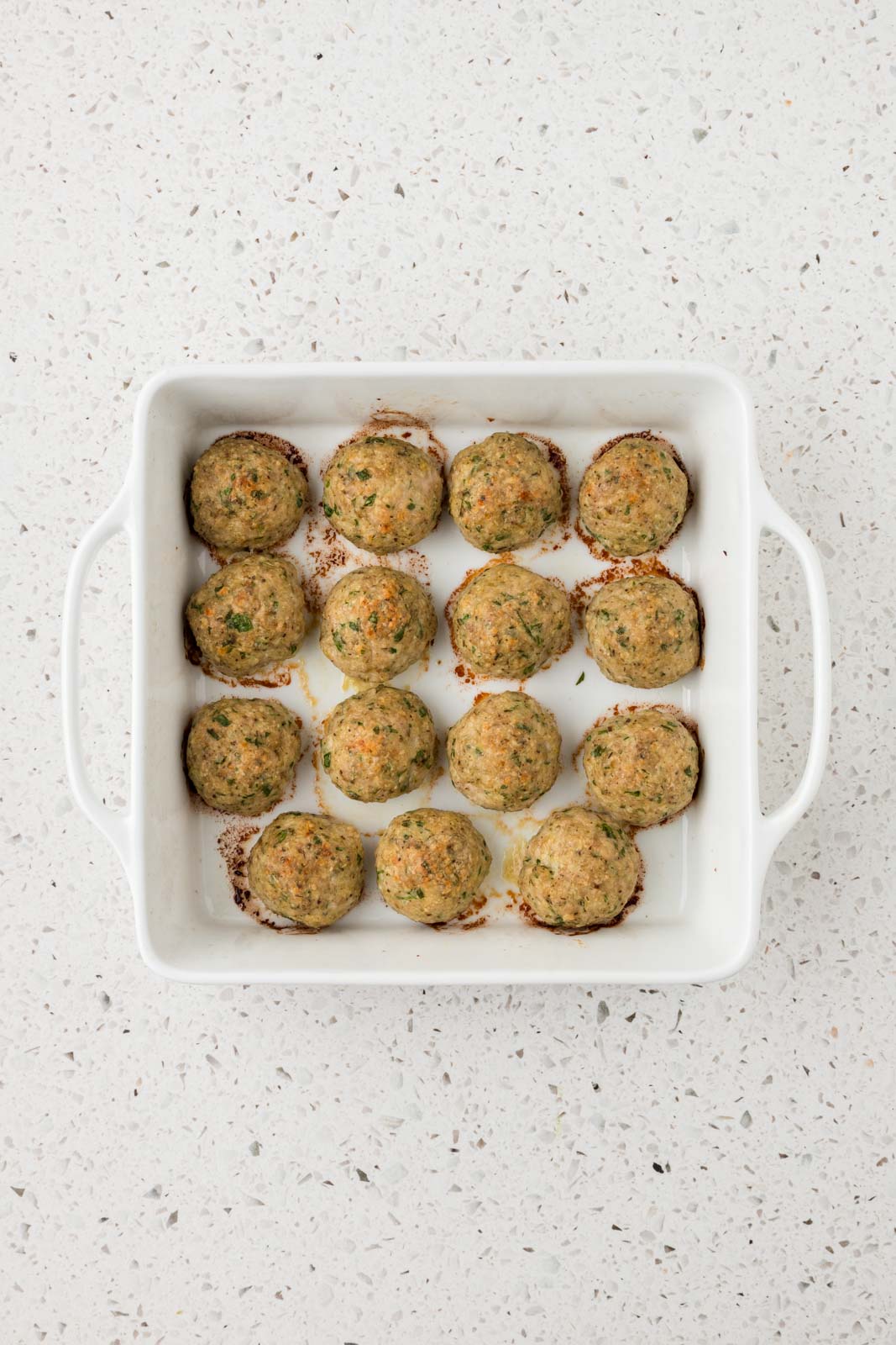 Baked Italian chicken meatballs in a baking dish.