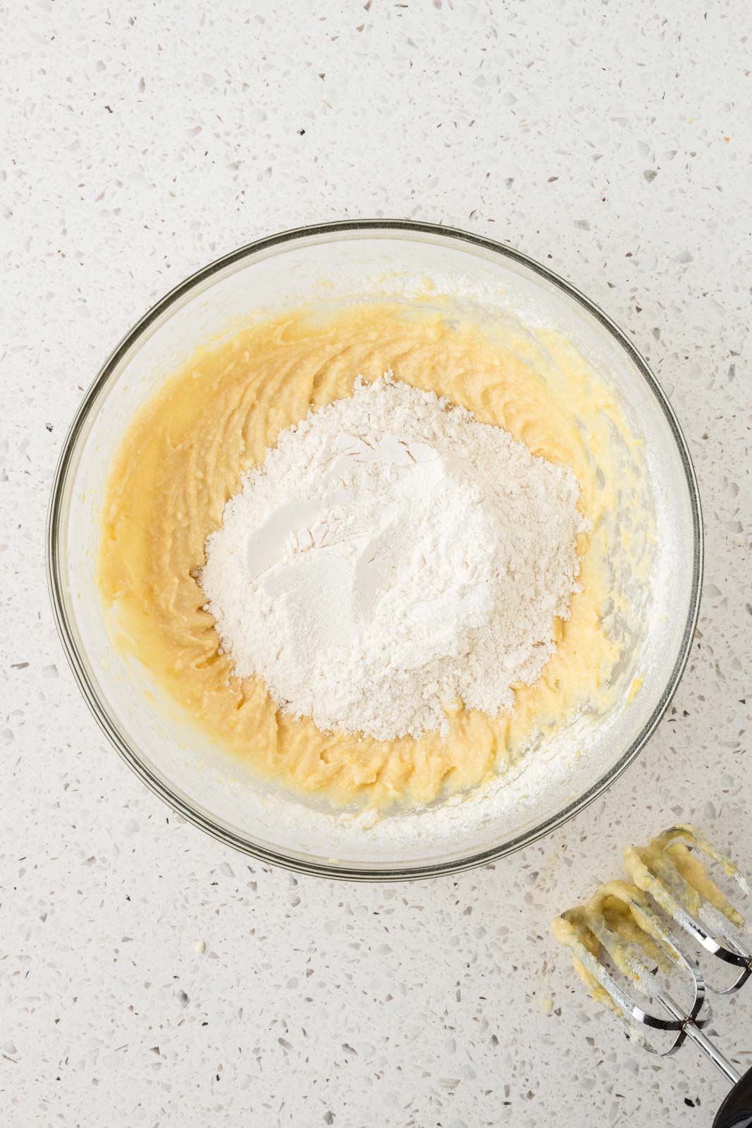 Dry and wet ingredients for lemon biscotti in a mixing bowl.