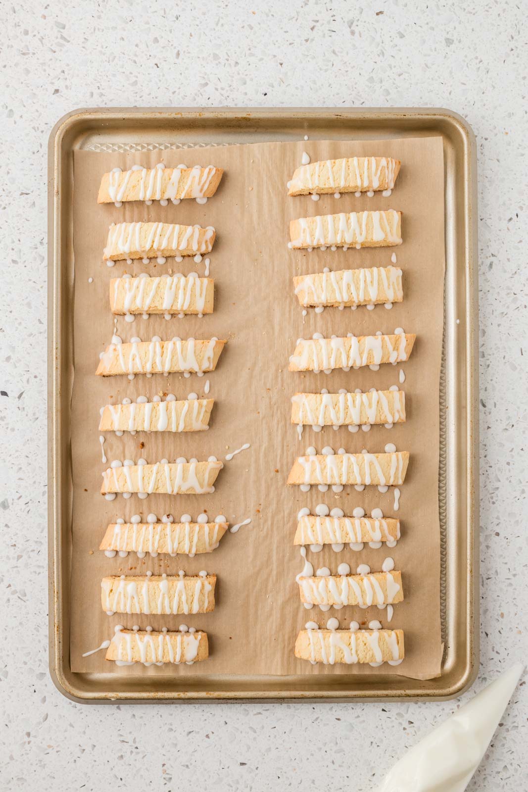 Lemon biscotti with icing on a baking sheet.