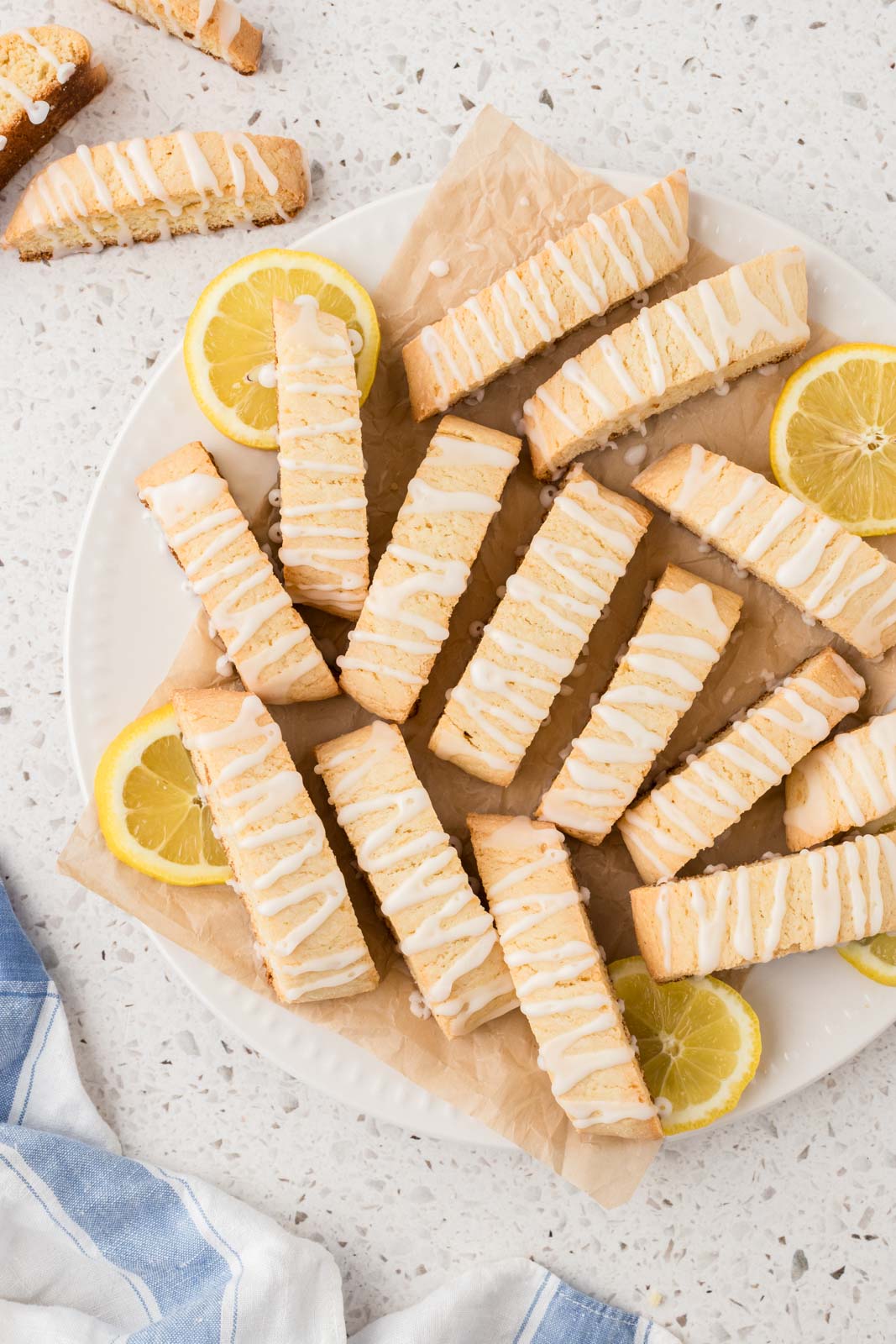 Lemon biscotti cookies on a plate with lemon garnish.