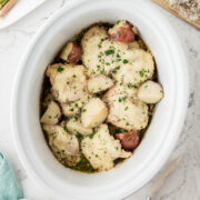 Garlic Parmesan Chicken and Potatoes in a white slow cooker.