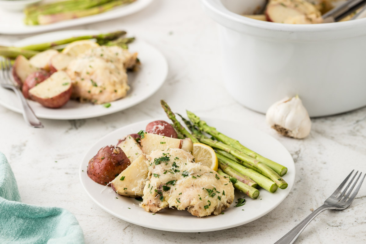 Garlic Parmesan Chicken and Potatoes plated with asparagus.