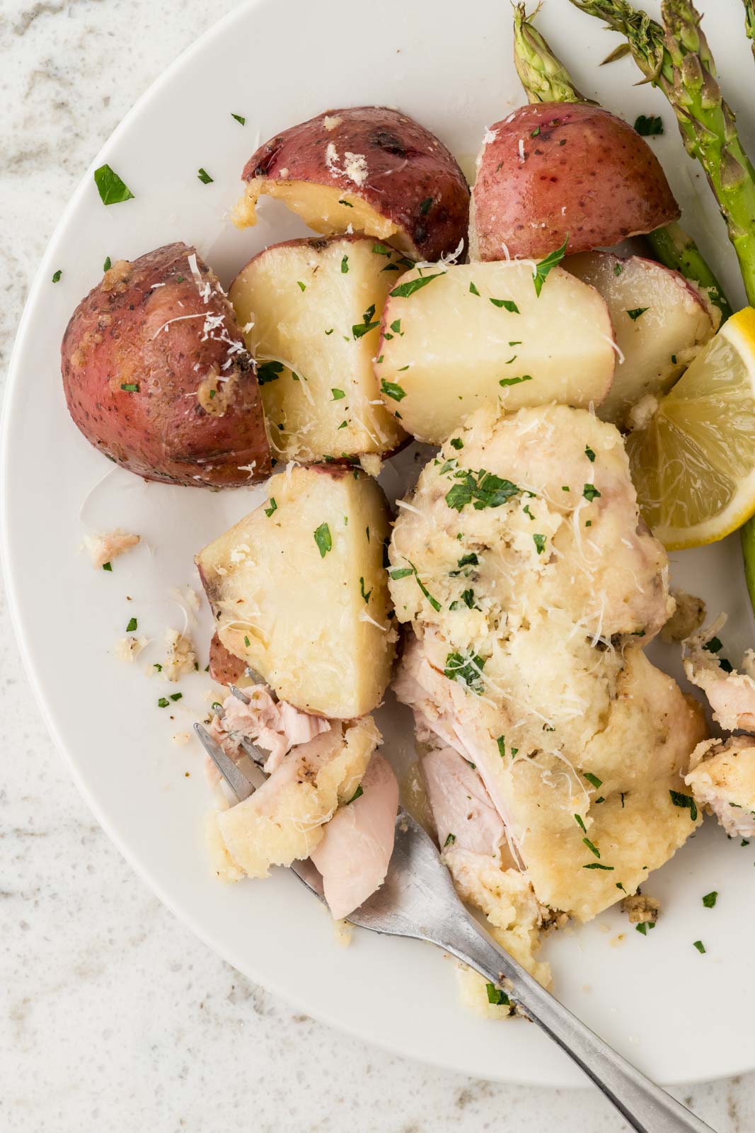 Garlic Parmesan Chicken and Potatoes on a plate with a fork.
