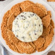 Cannoli dip surrounded by broken pizzelle cookies for dipping.