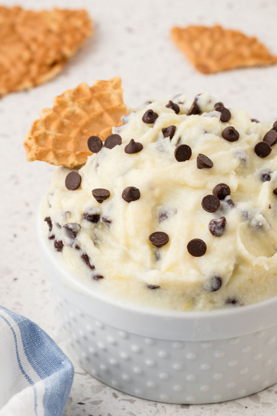 Cannoli dip in a bowl garnished with extra chocolate chips.