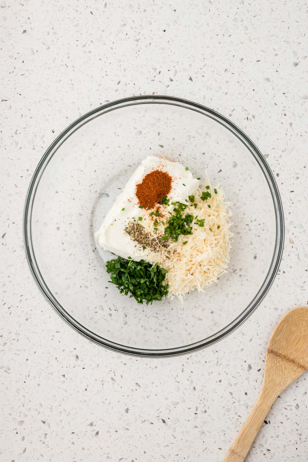 Seasonings, parmesan cheese, and cream cheese in a mixing bowl.