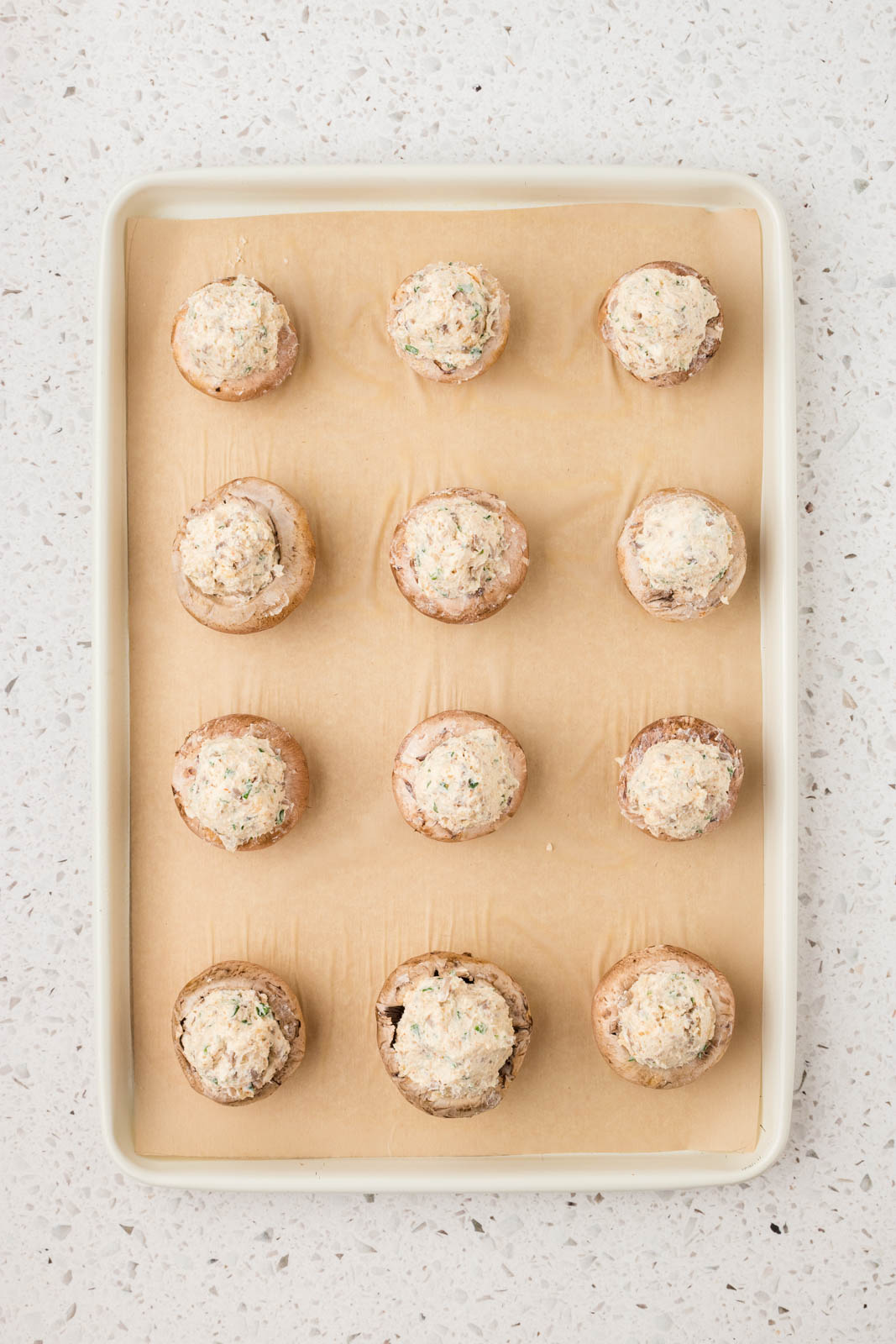 Italian stuffed mushrooms on a baking sheet ready for the oven.