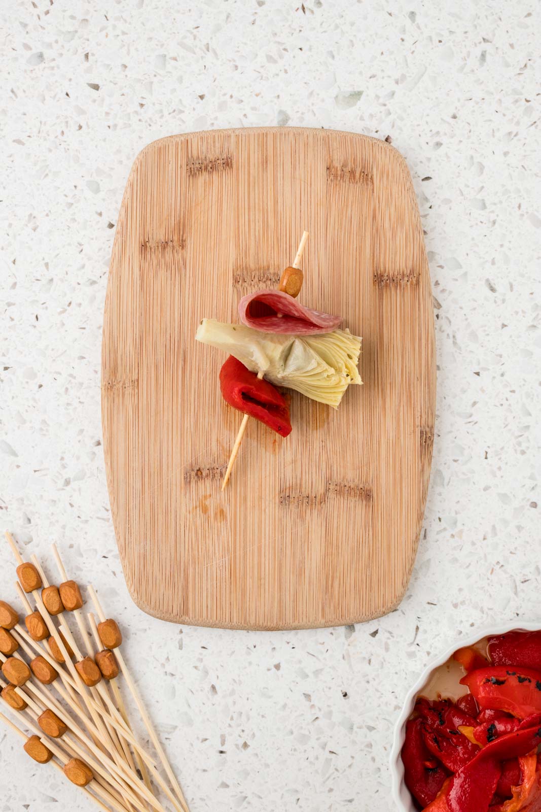 Mini antipasto skewer with roasted red pepper threaded on the end.