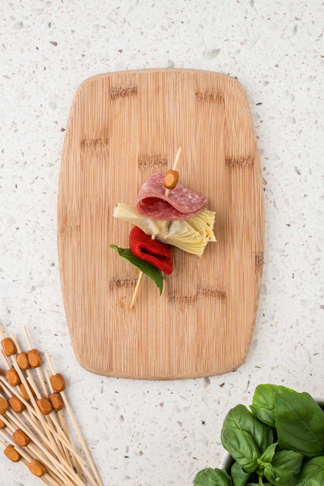 Mini antipasto skewer with basil leaf added to the end.
