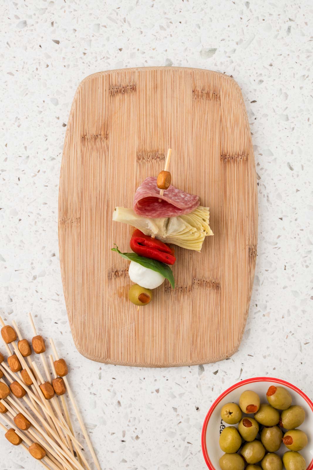 Olive placed on the end of the completed antipasto skewer.