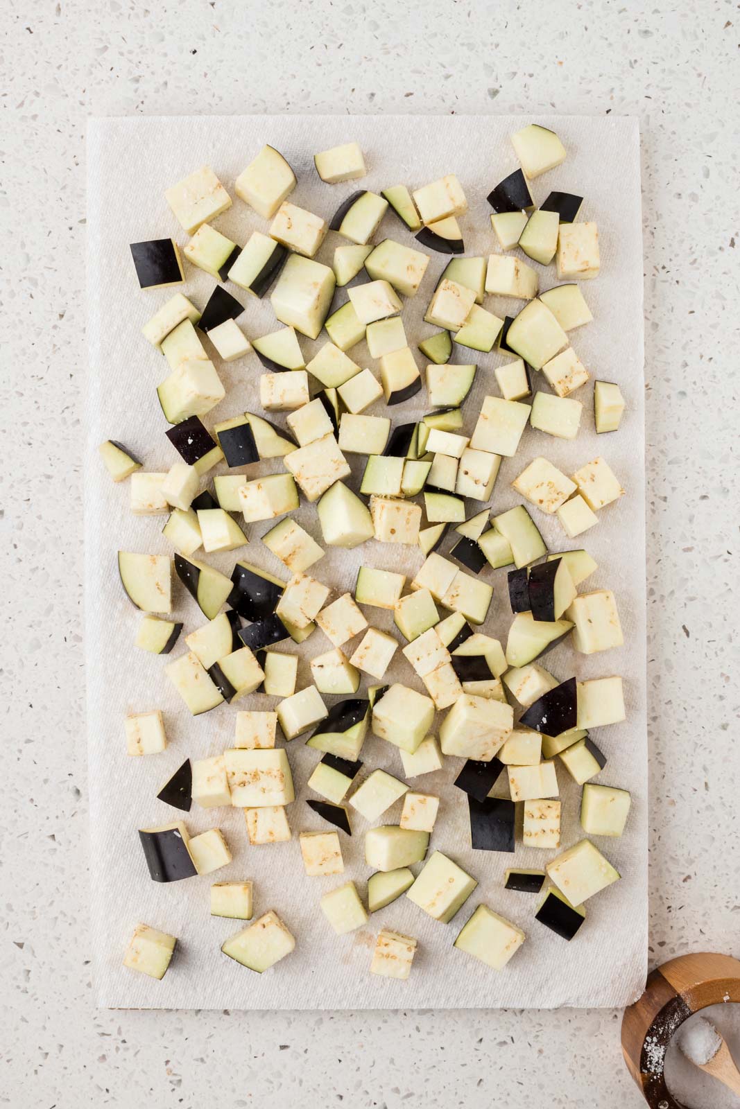 Eggplant sprinkled with salt on a paper towel.