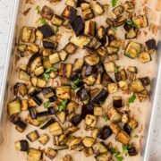 Roasted eggplant on a parchment-lined baking sheet.