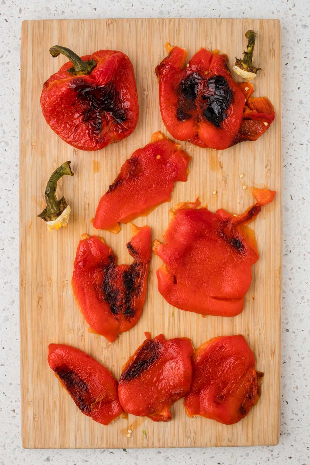 Roasted red peppers on a cutting board.
