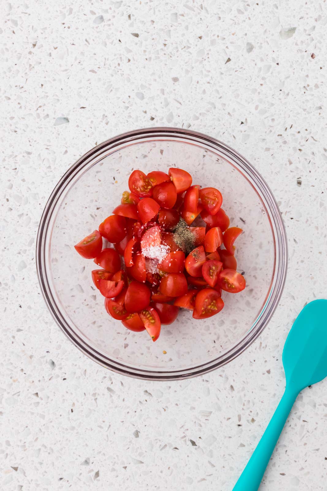 Chopped tomatoes and seasonings in a bowl.
