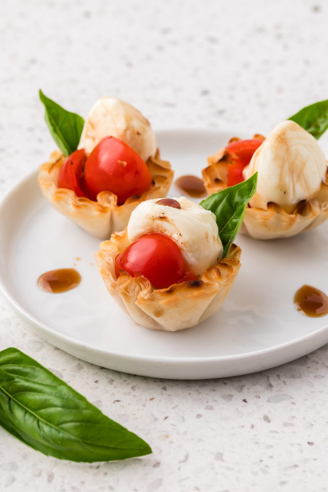 3 caprese cups on an appetizer plate.