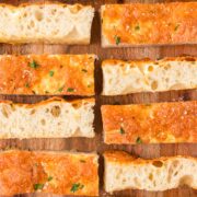 Cheesy Focaccia Bread sliced on a serving board.