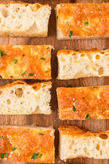 Cheesy Focaccia Bread sliced on a serving board.