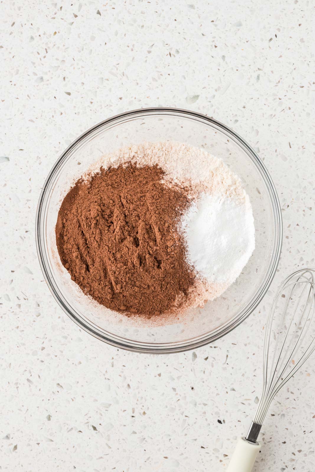 Dry ingredients in a mixing bowl with a whisk.