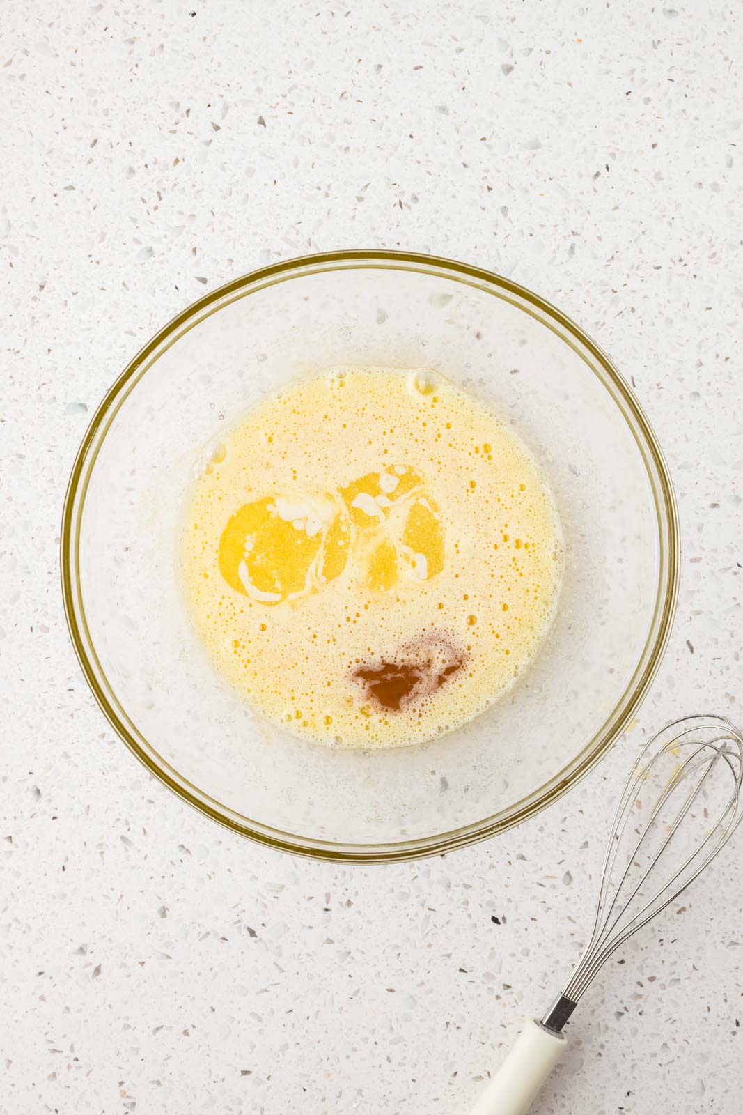 Eggs, vanilla, and melted butter in mixing bowl.