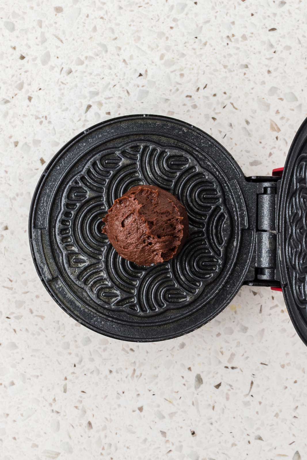 Pizzelle batter on pizzelle maker.