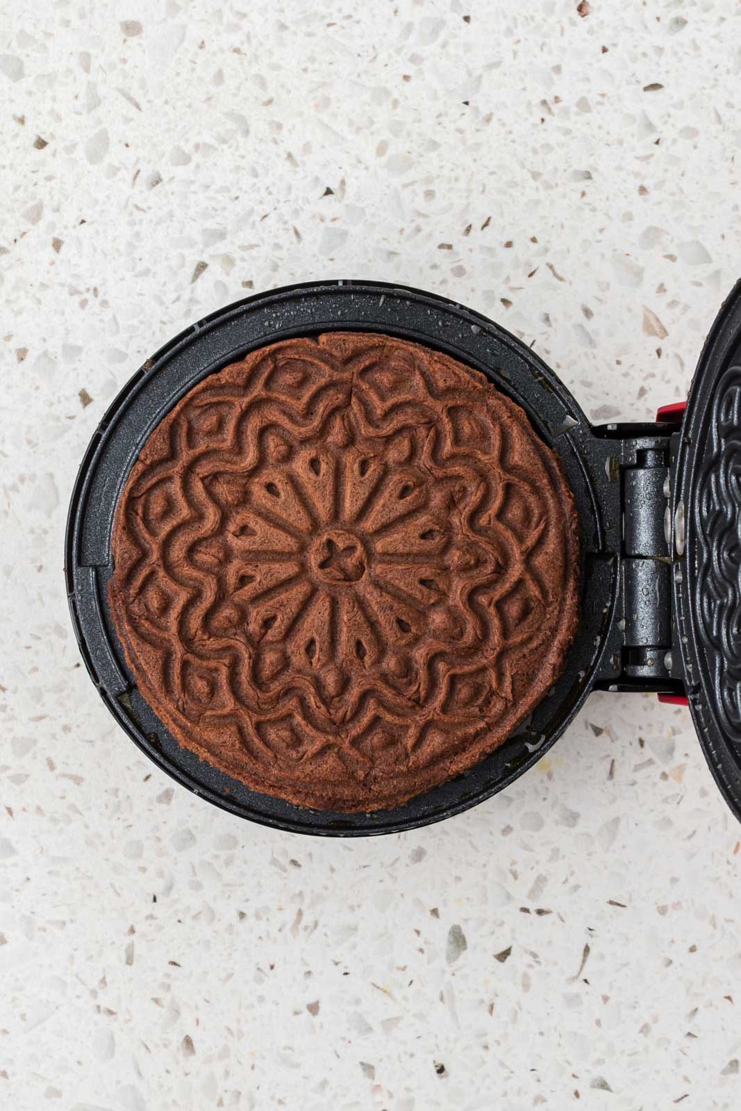 Cooked pizzelle on pizzelle maker.
