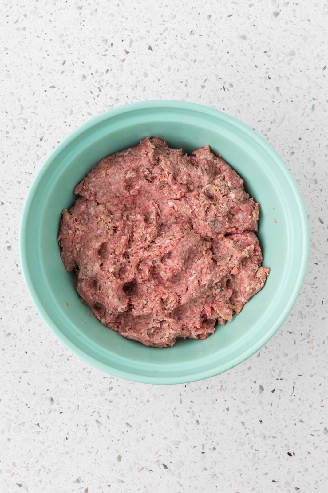 Meatball mixture combined in a mixing bowl.