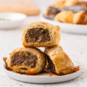 Italian sausage roll stacked on a appetizer plate.
