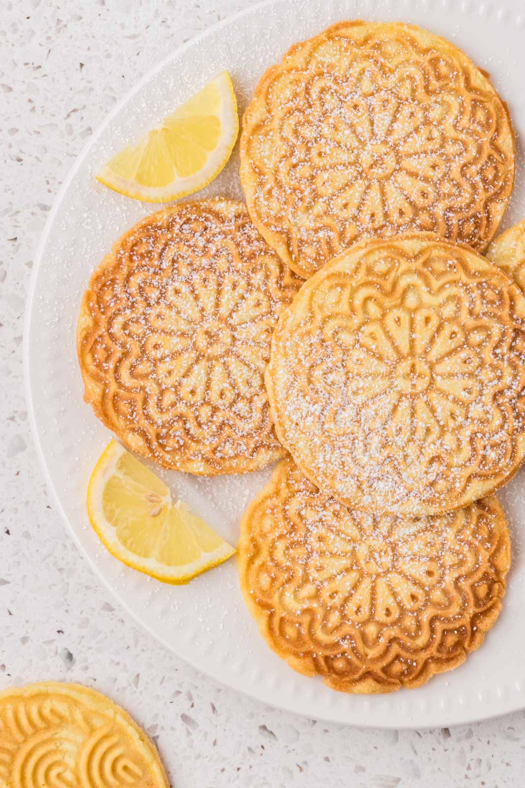 Lemon pizzelle on a plate with garnish.