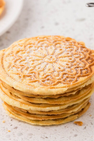 Stack of lemon pizzelle on countertop.