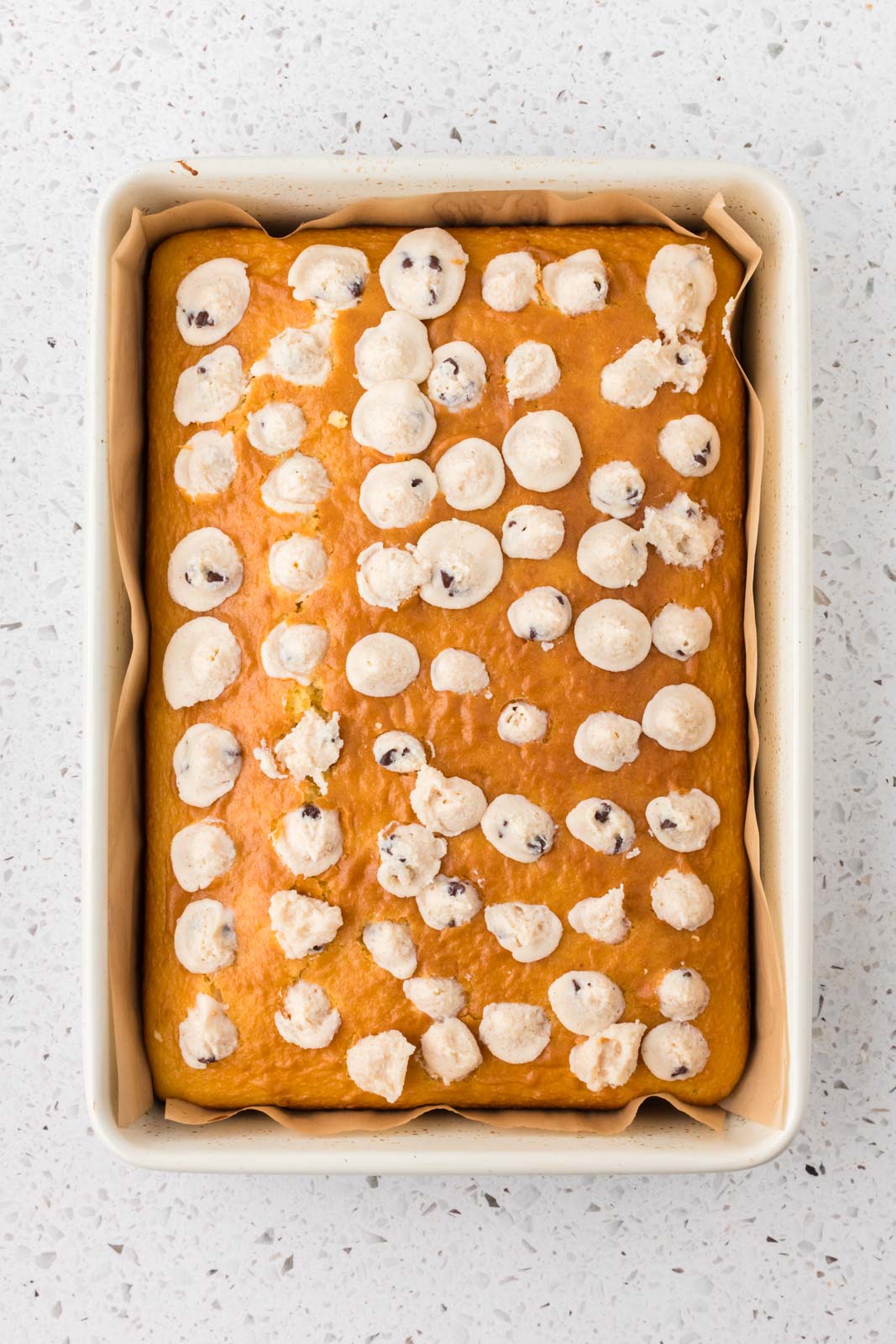 Cannoli poke cake with holes filled with cannoli filling.