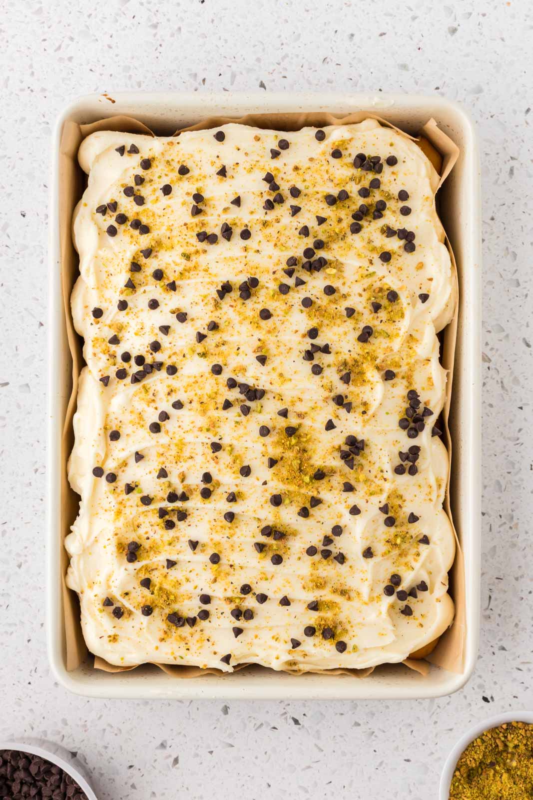 Cannoli cake with chocolate chip and pistachio garnish.