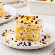 A piece of Cannoli Poke Cake on a plate.