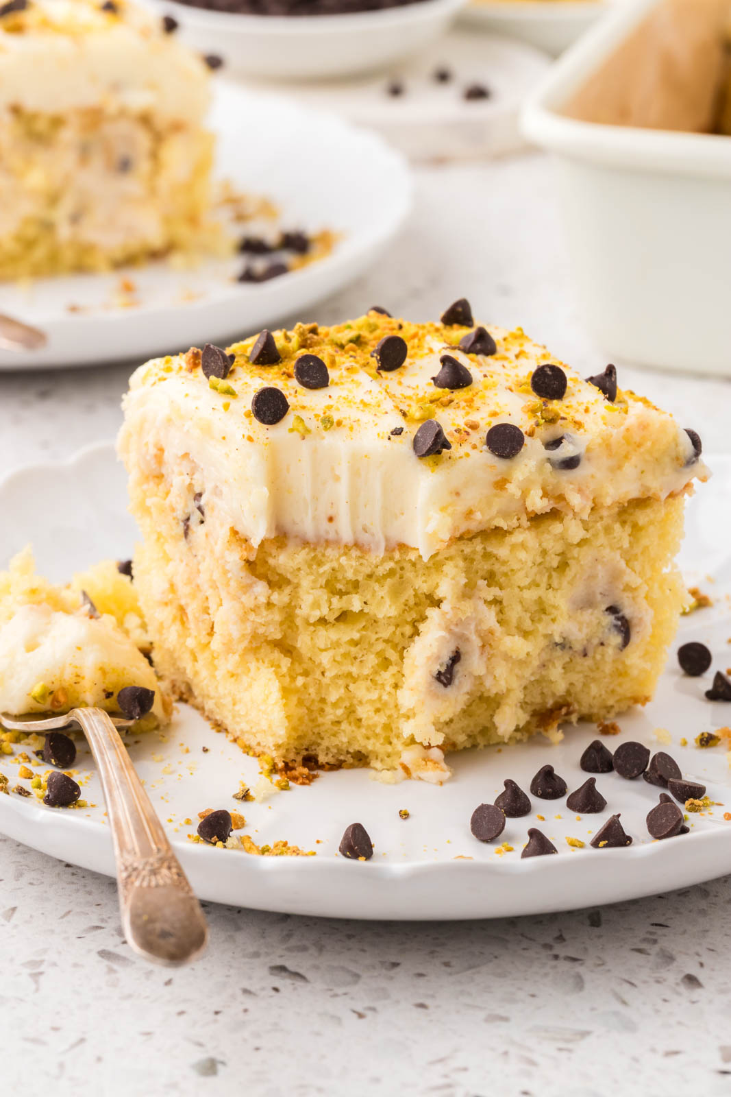 Cannoli Cake on a plate with a bite out of it.