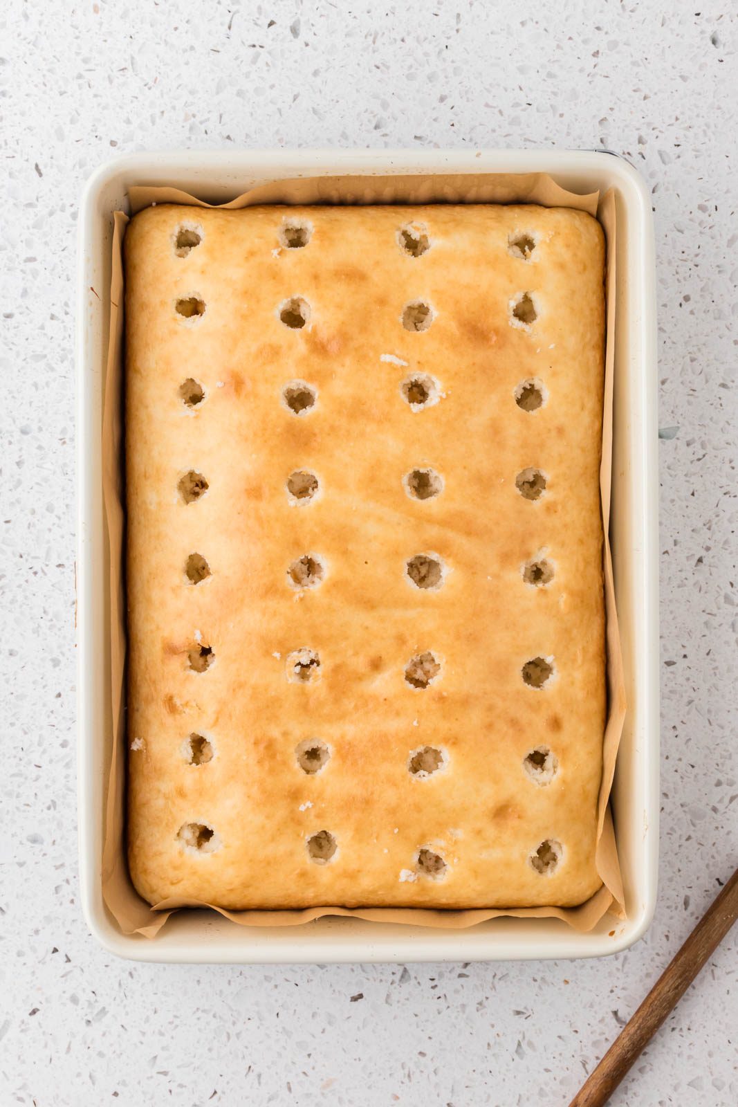 Cake poked with holes with the end of wooden spoon.