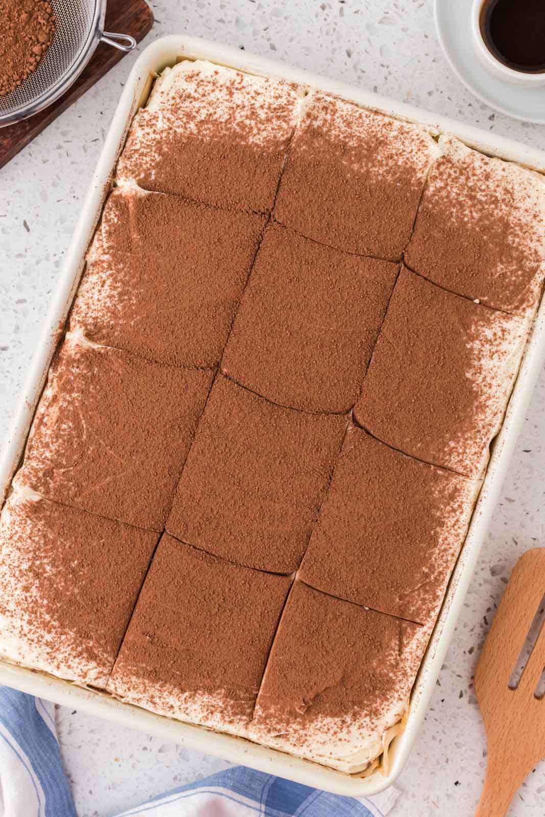 Tiramisu poke cake cut into pieces.