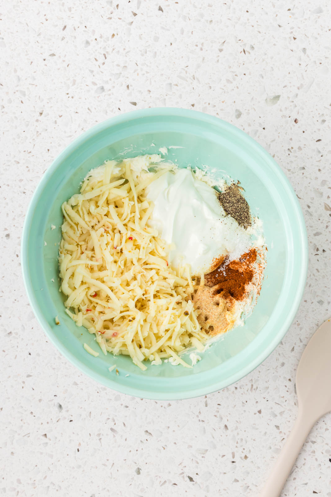 Shredded cheese and spices added to the mixture.