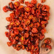 Roasted Cherry Tomatoes on a baking sheet with parchment paper.