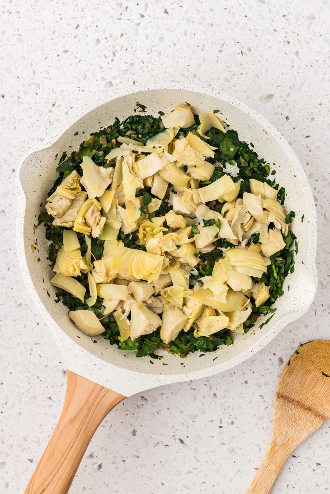 Chopped artichokes added to the saute pan. 