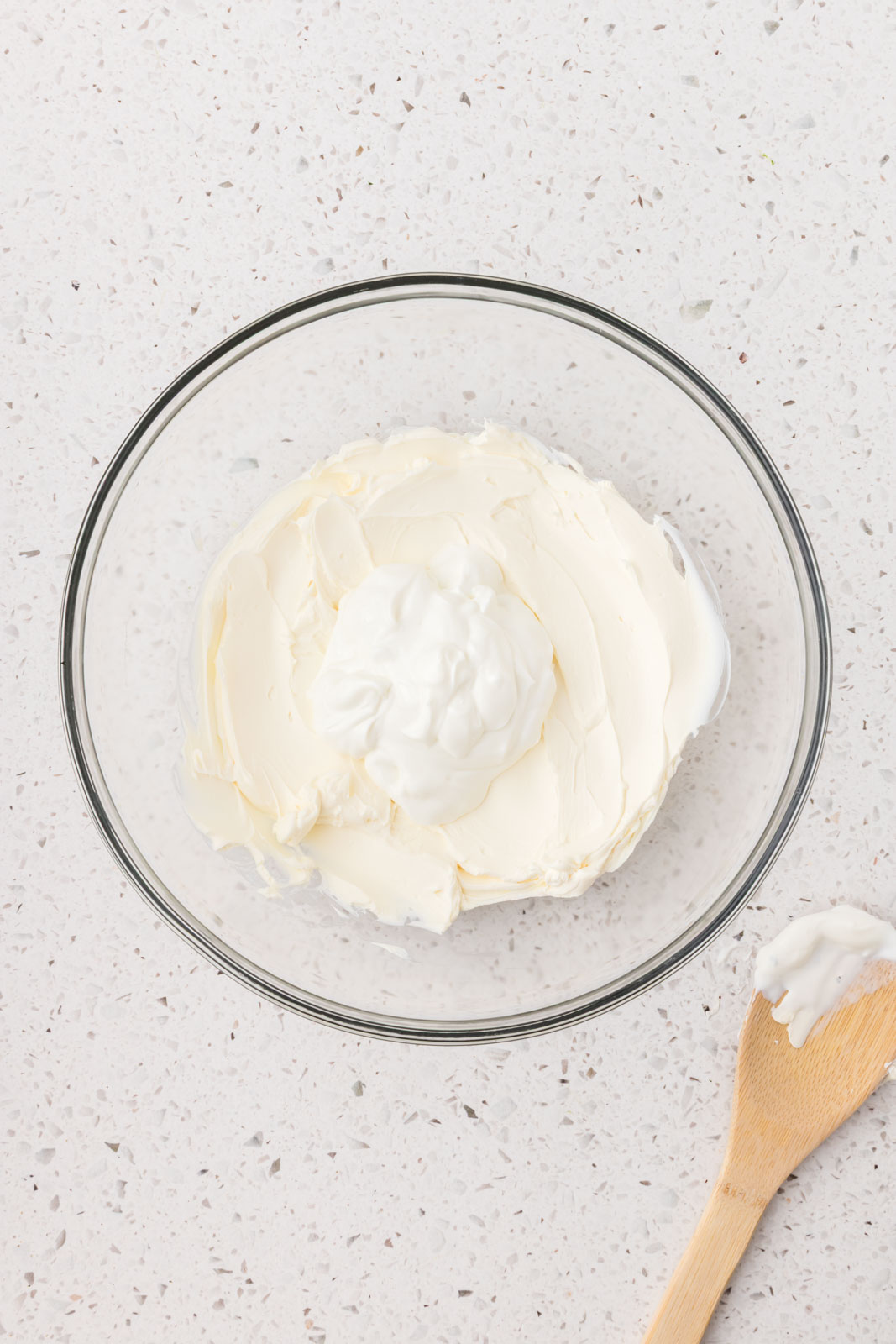 Cream cheese and yogurt in a mixing bowl. 